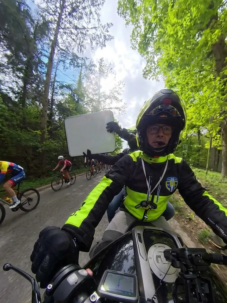 Motard du PMS présentant l'ardoise aux coureurs en pleine course
